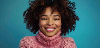 mulher com encaracolado cabelo sorridente dentro Rosa suéter contra azul fundo foto