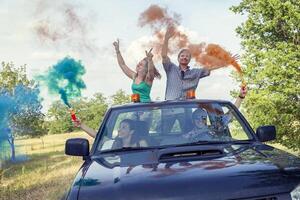 grupo do jovem rapazes ter Diversão com colori fumaça trilhas foto