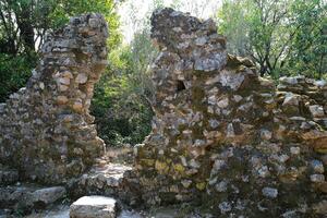 ruínas do a ótimo basílica dentro butrint nacional parque, butroto, Albânia. triconch Palácio às butrint vida e morte do a antigo romano casa histórico medieval veneziano torre cercado foto