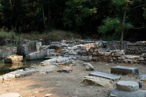 ruínas do a ótimo basílica dentro butrint nacional parque, butroto, Albânia. triconch Palácio às butrint vida e morte do a antigo romano casa histórico medieval veneziano torre cercado foto