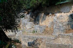 ruínas do a ótimo basílica dentro butrint nacional parque, butroto, Albânia. triconch Palácio às butrint vida e morte do a antigo romano casa histórico medieval veneziano torre cercado foto