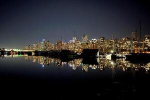 centro da cidade Vancouver em uma inverno tarde brilha dentro a crepúsculo contra uma pano de fundo do majestoso montanhas foto