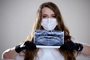 uma fêmea dentista examinando uma panorâmico radiografia. foto