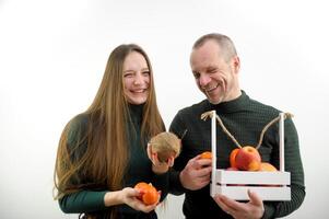 feliz jovem casal comendo frutas e saudável Comida casal compras para Comida junto. pai e filha pessoas quem Segue uma saudável dieta. homem e mulher com fresco frutas e legumes foto