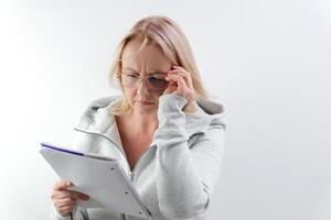 cansado caucasiano empresária levando fora Óculos e fricção olhos. retrato do Exausta mulher surfar Internet em computador portátil. loiro lindo mulher excesso de trabalho on-line. controlo remoto trabalhando. foto