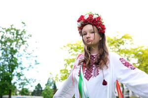 fofa jovem menina adolescente ucraniano mulher dentro folk tradicional desenvolve dela cachos lindo guirlanda com muitos flores fitas natureza fêmea natural beleza folk imagem natureza árvores folhagem mulher foto