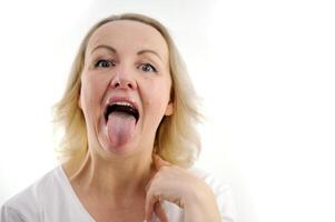 uma mulher mostra dela língua saudável limpar \ limpo língua fêmea língua com uma branco Revestimento. isolado em branco fundo. gastrointestinal doença, órgão disfunção, pobre oral higiene, fungoso infecções foto