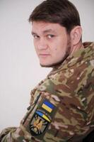 ucraniano soldado vestindo militares uniforme ucraniano emblema e nacional símbolo meio do exército soldado armado forças do Ucrânia ucraniano dentro exército. ucraniano bandeira em militares uniforme foto