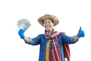 ásia mulher agricultor desgasta chapéu, azul camisa, tanga lenço, detém tailandês nota de banco dinheiro, isolado em branco fundo. conceito, agricultura ocupação. tailandês agricultor. lucro, renda. foto