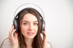 panorâmico arquivo lateral fechar-se foto do lindo jovem mulher vestindo à moda casual equipamento isolado sobre colorida fundo parede vestindo branco sem fio fones de ouvido e ouvindo para música e usando