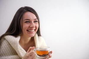 lindo jovem mulher bebendo saboroso chá às casa foto