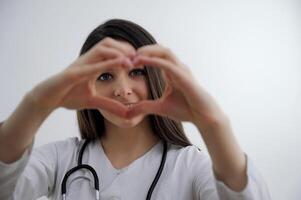 menina mostrando coração com dela mãos jovem jovem médico olhando através mãos ajudando fechar parentes e Boa pessoas hipocrático juramento Socorro Cuidado médico segredo amor tratamento cardiologia coração hospital foto