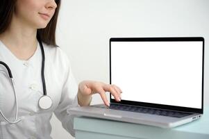 fêmea médico assistente desgasta branco casaco, fone de ouvido chamando distante paciente em computador portátil. médico falando para cliente usando virtual bate-papo computador aplicativo. telemedicina, controlo remoto cuidados de saúde Serviços conceito. foto