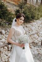 uma mulher é segurando uma ramalhete do branco flores e vestindo uma branco Casamento vestir foto