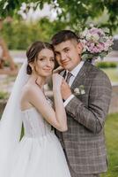 uma noiva e noivo estão posando para uma cenário com uma ramalhete do flores foto