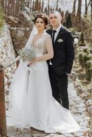 a noiva e noivo estão caminhando dentro natureza em seus Casamento dia. uma homem abraços uma mulher. Casamento retrato foto