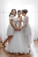 três mulheres estão posando para uma foto, com 1 do eles vestindo uma Casamento vestir foto