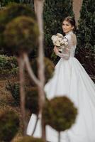 uma mulher dentro uma branco vestir é segurando uma ramalhete do flores foto