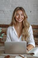 mulher sentado às mesa com computador portátil foto