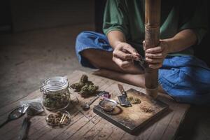 uma homem prepara maconha em uma corte borda para fumaça, pessoa quem fuma drogas, droga viciado, drogas vício e retirada sintomas conceito. drogasinternacional dia contra droga Abuso. foto