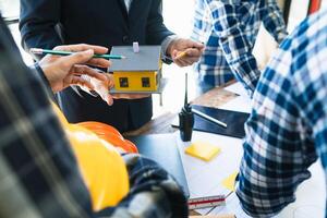 equipe do engenheiros e designers tem venha juntos para Projeto a energia salvando casa ou verde energia casa este usa natural energia tal Como vento turbinas e solar células para gerar eletricidade para lar. foto