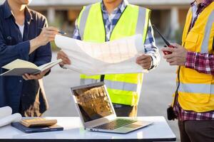 arquitetos e designers estão falando sobre construção planos antes ser entregue para a Engenharia equipe e capatazes para construção. auditar conceito planos a partir de uma equipe do arquitetos e designers foto