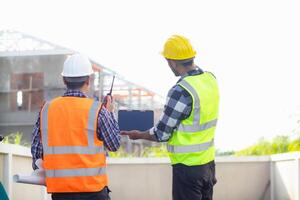 arquitetos e designers estão falando sobre construção planos antes ser entregue para a Engenharia equipe e capatazes para construção. auditar conceito planos a partir de uma equipe do arquitetos e designers foto