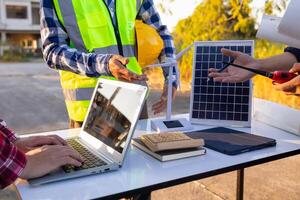 equipe do engenheiros e designers tem venha juntos para Projeto a energia salvando casa ou verde energia casa este usa natural energia tal Como vento turbinas e solar células para gerar eletricidade para lar. foto