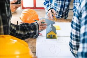 equipe do engenheiros e designers tem venha juntos para Projeto a energia salvando casa ou verde energia casa este usa natural energia tal Como vento turbinas e solar células para gerar eletricidade para lar. foto