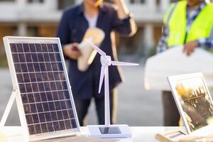 equipe do engenheiros e designers tem venha juntos para Projeto a energia salvando casa ou verde energia casa este usa natural energia tal Como vento turbinas e solar células para gerar eletricidade para lar. foto