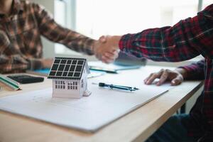 equipe do engenheiros e designers tem venha juntos para Projeto a energia salvando casa ou verde energia casa este usa natural energia tal Como vento turbinas e solar células para gerar eletricidade para lar. foto