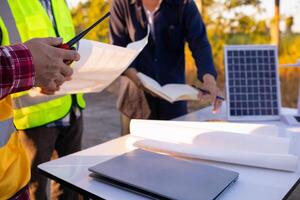 equipe do engenheiros e designers tem venha juntos para Projeto a energia salvando casa ou verde energia casa este usa natural energia tal Como vento turbinas e solar células para gerar eletricidade para lar. foto