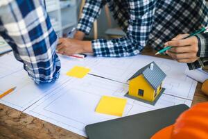 equipe do engenheiros e designers tem venha juntos para Projeto a energia salvando casa ou verde energia casa este usa natural energia tal Como vento turbinas e solar células para gerar eletricidade para lar. foto