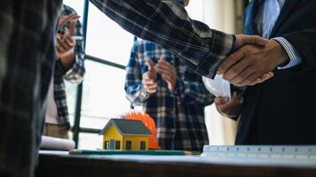 arquitetos e designers estão falando sobre construção planos antes ser entregue para a Engenharia equipe e capatazes para construção. auditar conceito planos a partir de uma equipe do arquitetos e designers foto