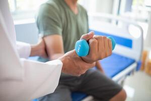 médico é ajudando uma paciente mover dela músculos depois de recuperando a partir de uma músculo prejuízo e querendo para reabilitar dela para estar capaz para usar dela normal diariamente vida com contínuo fisica terapia. foto