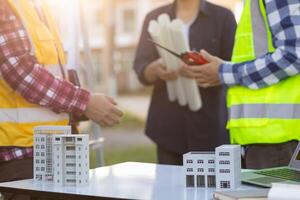 equipe do engenheiros e designers tem venha juntos para Projeto a energia salvando casa ou verde energia casa este usa natural energia tal Como vento turbinas e solar células para gerar eletricidade para lar. foto