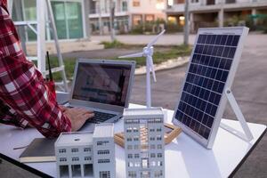 equipe do engenheiros e designers tem venha juntos para Projeto a energia salvando casa ou verde energia casa este usa natural energia tal Como vento turbinas e solar células para gerar eletricidade para lar. foto