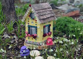 fofa fada boneca casa com Primavera flores lado de fora dentro a jardim. adorável miniatura para cumprimento cartões, Casamento ou aniversário conceito, real Estado, redução de tamanho, casa propriedade foto