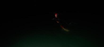 nadador de triatleta autêntico tendo uma pausa durante o treinamento duro na noite foto