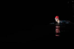 nadador de triatleta autêntico tendo uma pausa durante o treinamento duro na noite foto