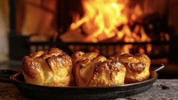 esses dourado Castanho yorkshire pudins ter ressuscitado belas ao lado a acolhedor calor do a lareira pronto para estar devorado com uma domingo assado foto