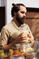 homem dentro zero desperdício loja levando Tempo para analisar massa produtos, fazer certo elas conter não alérgenos. cliente completamente verificação Comida Itens estão seguro dentro ambientalmente consciente local fazer compras foto