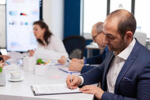 homem de negocios lendo papel documento, discutindo contrato com confiante parceiro, assinatura investimento papéis. executivo diretor encontro acionistas dentro começar acima escritório, fazer satisfatoriamente acordo. foto