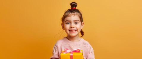 animado jovem menina segurando uma presente caixa com uma dourado fita. feliz criança recebendo uma presente. conceito do celebrações, surpresa, alegria, e infância excitação. cópia de espaço foto