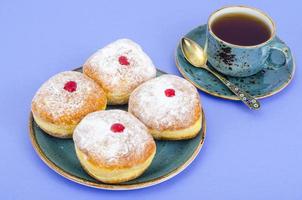 donuts de comida tradicional com açúcar de confeiteiro e geléia. conceito e plano de fundo feriado judaico hanukkah. foto