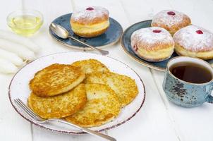 conceito e plano de fundo feriado judaico hanukkah. donuts de comida tradicional e latkes de panquecas de batatas. leito plano ou vista superior. foto