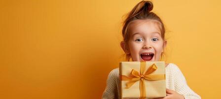 animado jovem menina segurando uma presente caixa com uma dourado fita. feliz criança recebendo uma presente. conceito do celebrações, surpresa, alegria, e infância excitação. cópia de espaço foto