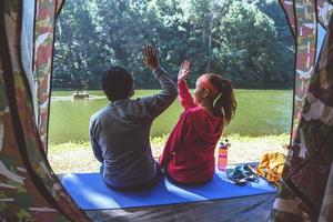 casal viaja para camping em uma floresta de pinheiros à beira do lago em pang oung lago mae hong son, tailândia.