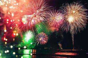 fogos de artifício com silhuetas de pessoas em um feriado events.new ano fogos de artifício na praia. viajantes e pessoas comemoram o ano novo em kamala beach phuket, tailândia. foto