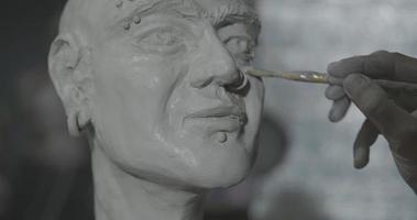 escultor trabalhando com retrato de mulher em argila no escuro estúdio uhd4k foto